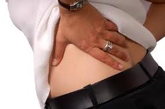 Image of pateint holding their lower back from pain 